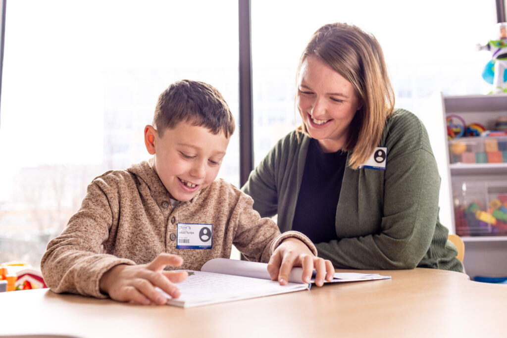 mom and son reading together at a table