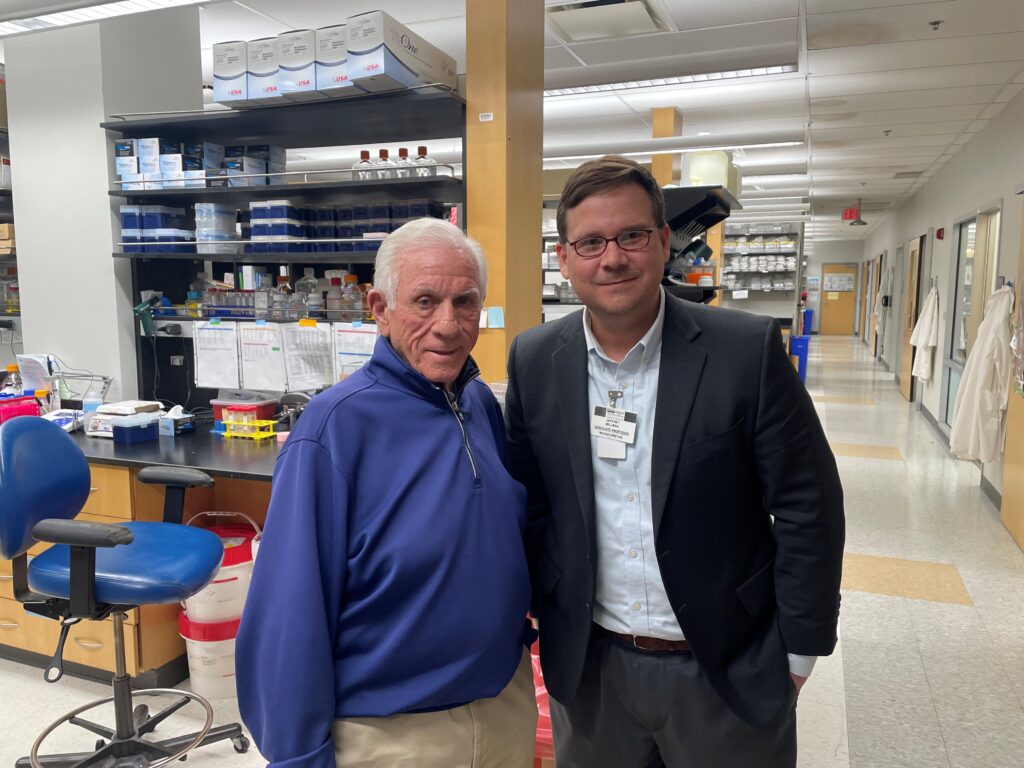 Portrait of a patient next to his doctor in the lab where they conduct research