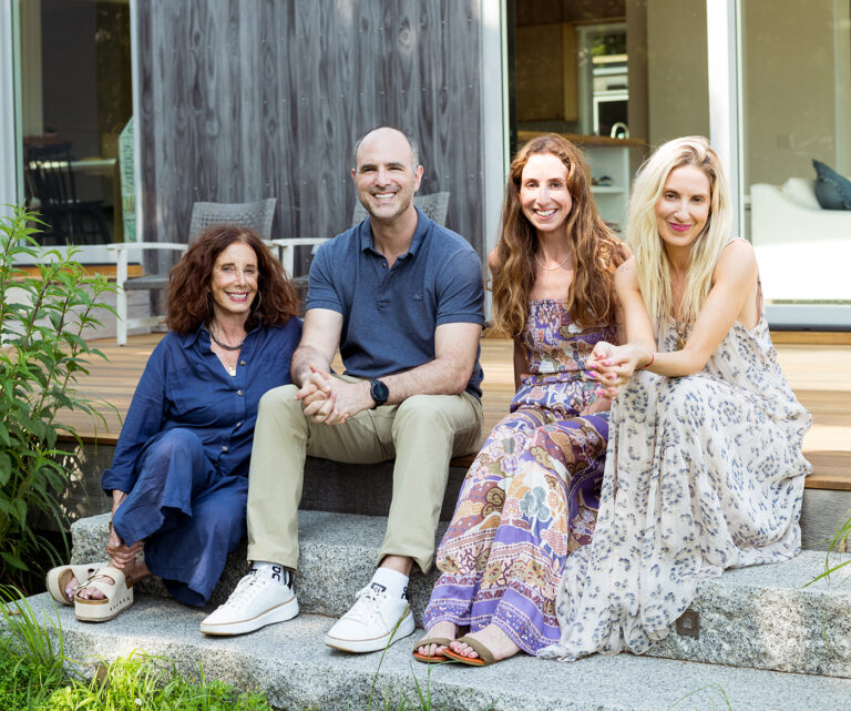 A family portrait in the backyard of a house on a sunny day