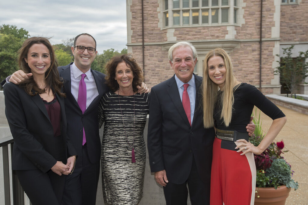 A group family photo with everyone dressed up on a university campus