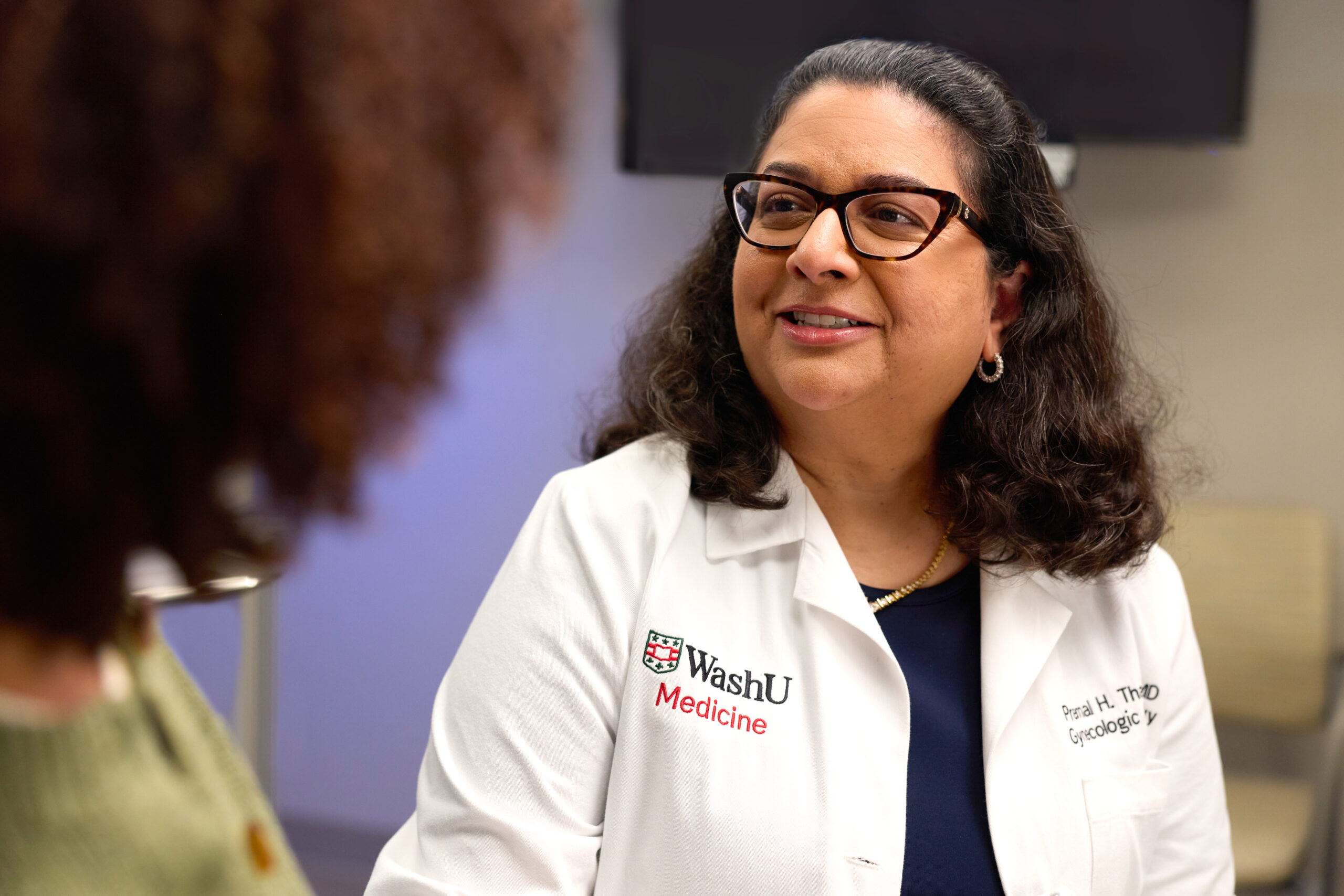 Dr. Premal Thaker, MD, MS, wearing a WashU Medicine lab coat, smiles as she speaks with a patient.