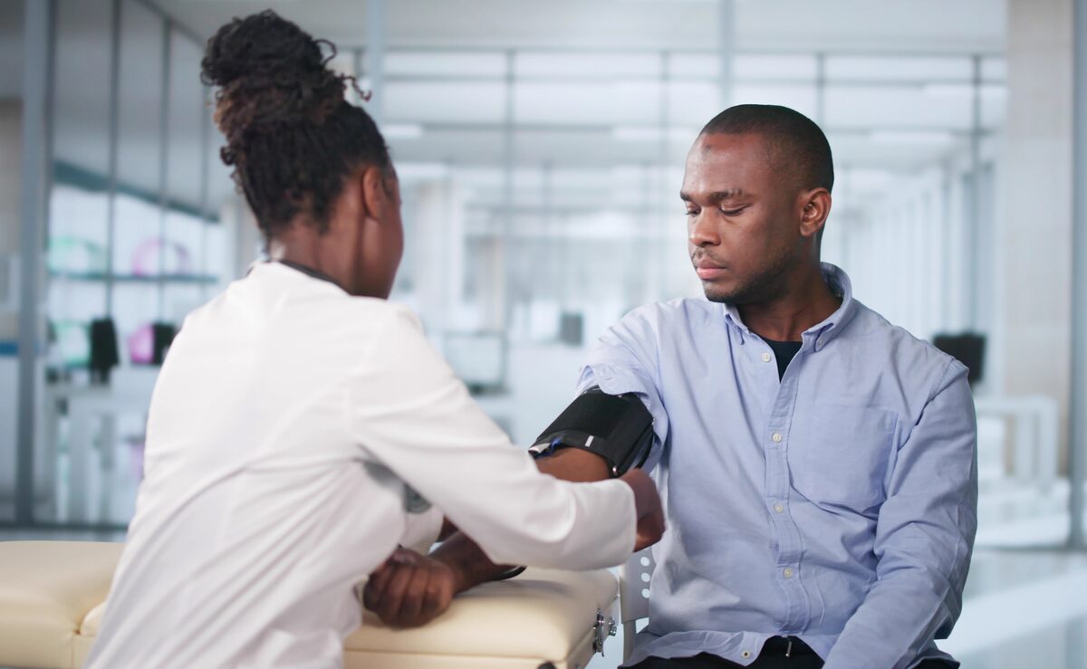 Nurse checking blood pressure of a male patient